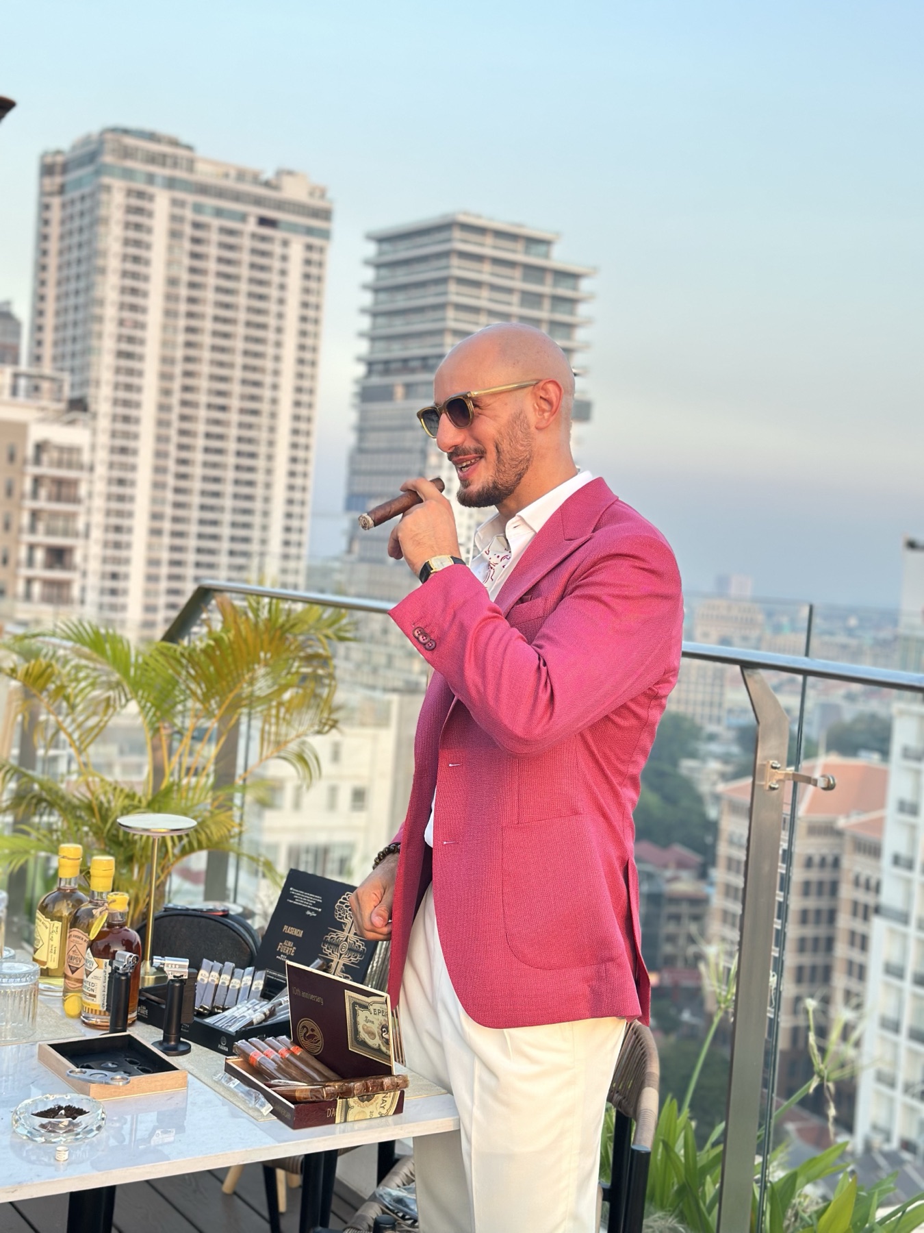 Red Raven founder with cigar and cigar humidor on a Phnom Penh rooftop