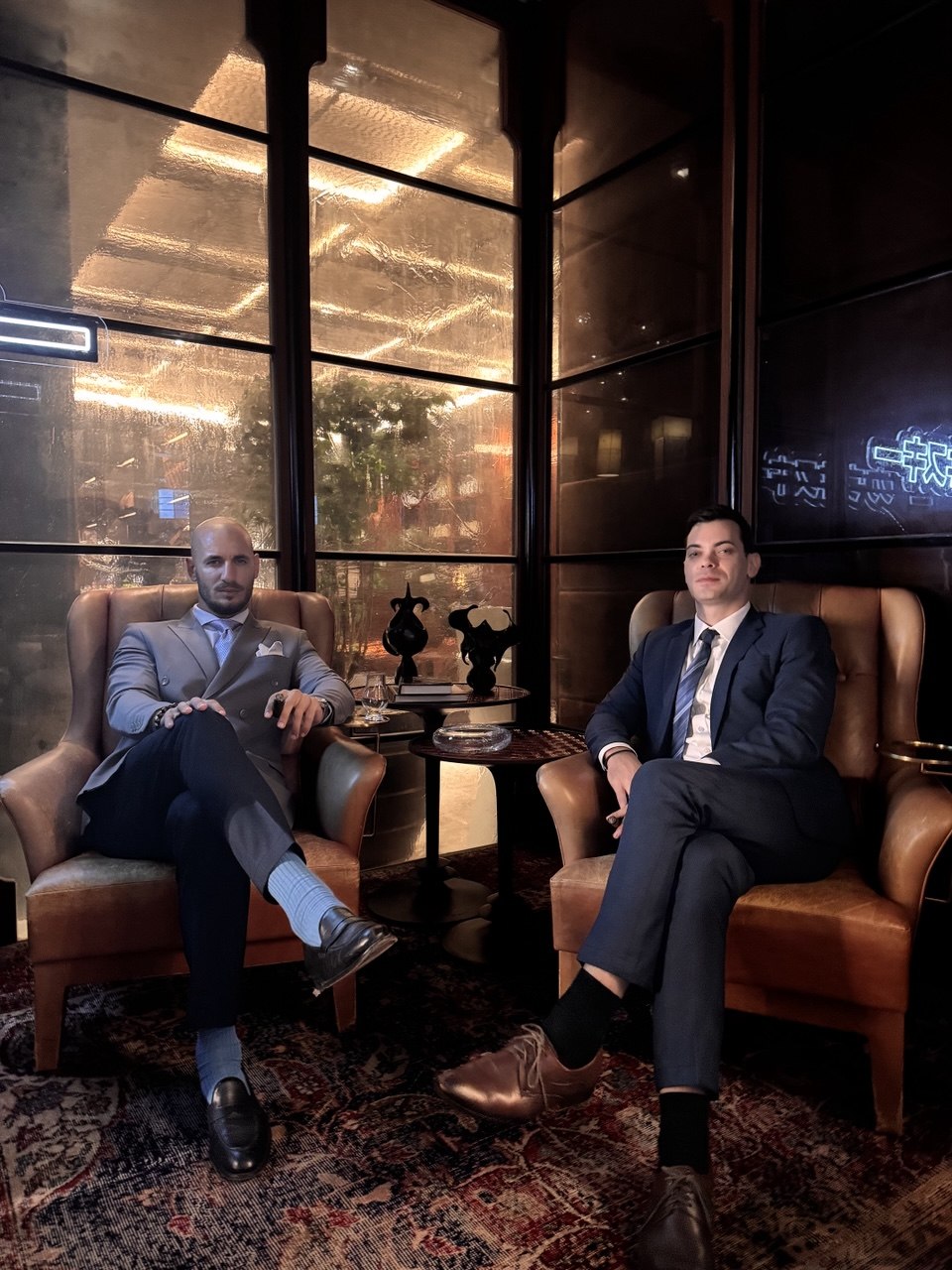 The Red Raven founders seated in a Phnom Penh cigar lounge